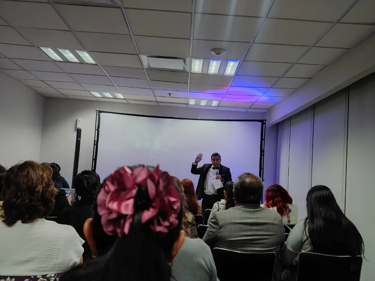 Carlos Román Samperio dando una conferencia frente a una sala llena de madres y padres